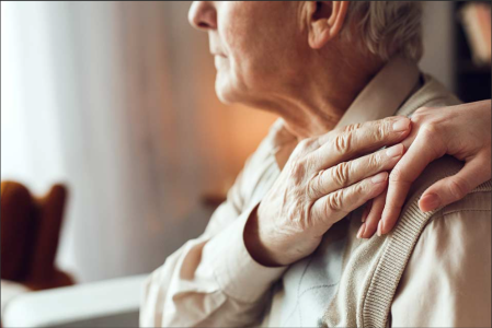 Photo of younger person comforting elderly person